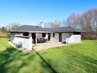 a white house with a black roof and a yard at 6 person holiday home in Vesløs-By Traum in Øsløs