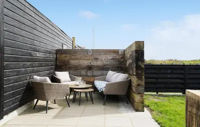 a patio with wicker chairs and a table at 3 Bedroom Nice Home In Thyborøn in Thyborøn
