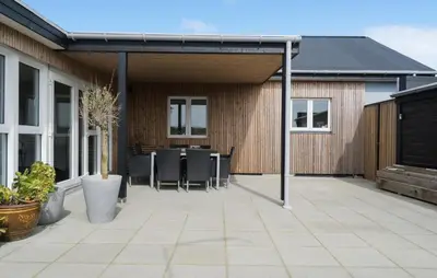 an outdoor patio with awning and tables and chairs at 3 Bedroom Nice Home In Thyborøn in Thyborøn