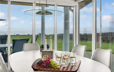 a dining room with a white table and chairs and a window at 3 Bedroom Amazing Home In Spøttrup in Spottrup