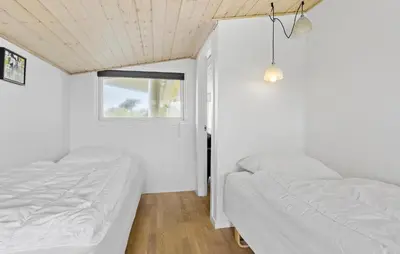 two beds in a small room with a window at 3 Bedroom Amazing Home In Spøttrup in Spottrup
