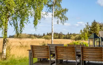 a table and chairs with a view of a field at 4 Bedroom Gorgeous Home In Fur in Furland