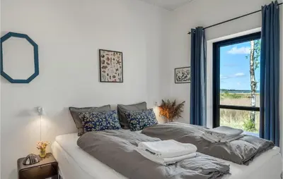 a bed in a room with a large window at 4 Bedroom Gorgeous Home In Fur in Furland