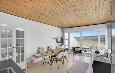 a living room with a wooden ceiling and a table and chairs at Gorgeous Apartment In Vestervig in Vestervig