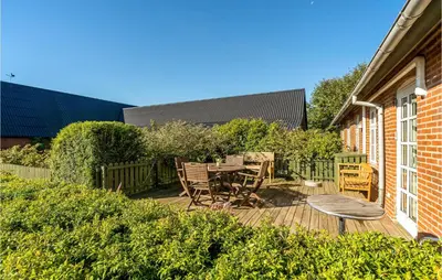 a patio with a table and chairs on a deck at 5 Bedroom Awesome Home In Erslev in Erslev
