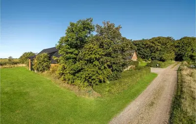 a dirt road next to a house with a tree at 5 Bedroom Awesome Home In Erslev in Erslev