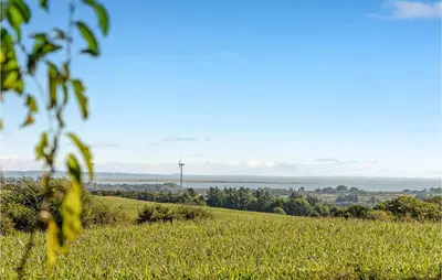a field of grass with the ocean in the background at 5 Bedroom Awesome Home In Erslev in Erslev