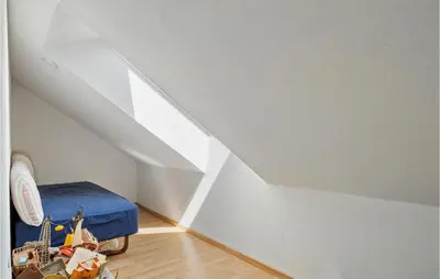 a attic room with a bed and a white wall at Nice Home In Øster Assels With Wifi in Øster Assels