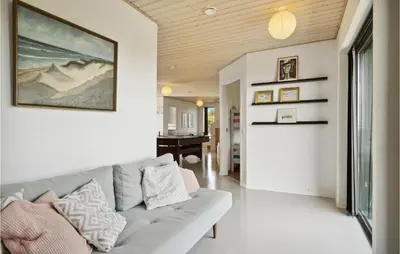 a living room with a couch and a table at Nice Home In Øster Assels With Wifi in Øster Assels