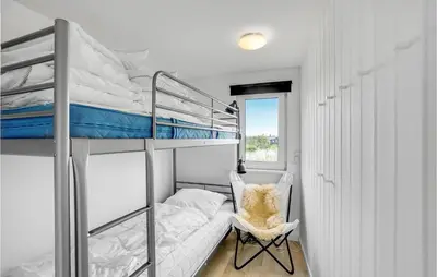 a bedroom with two bunk beds and a chair at Cozy Home In Thisted With Wifi in Thisted