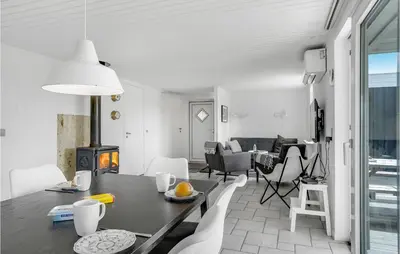 a dining room and living room with a table and chairs at Cozy Home In Thisted With Wifi in Thisted