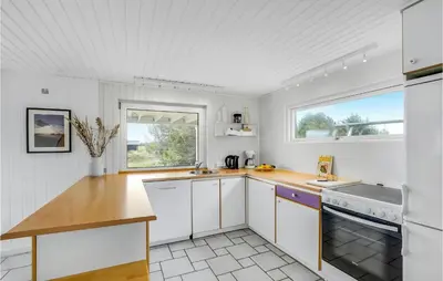 a kitchen with white cabinets and a sink and a window at Cozy Home In Thisted With Wifi in Thisted