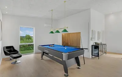 a room with a pool table and a chair at Nice Home In Spøttrup With Sauna in Spottrup