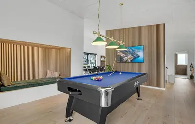 a pool table in a living room with a pool at Nice Home In Spøttrup With Sauna in Spottrup