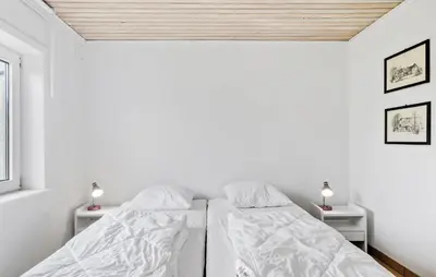 two beds in a white room with two lamps at 3 Bedroom Amazing Home In Vesløs in Øsløs