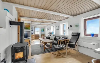 a living room with a wood stove in a room at Gorgeous Home In Thyholm With Kitchen in Thyholm