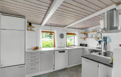 a kitchen with white cabinets and a wooden ceiling at Gorgeous Home In Thyholm With Kitchen in Thyholm