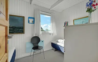 a bedroom with a chair and a bed and a window at 2 Bedroom Nice Home In Roslev in Roslev