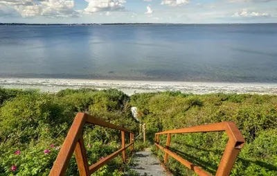 a staircase leading to a beach with the ocean at 2 Bedroom Nice Home In Roslev in Roslev