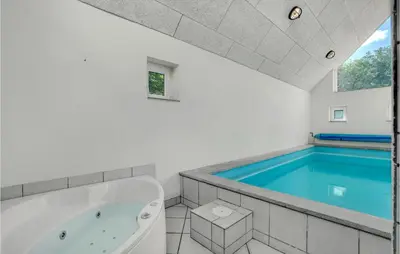 a bathroom with a tub and a swimming pool at Amazing Home In Vestervig With Sauna in Vestervig