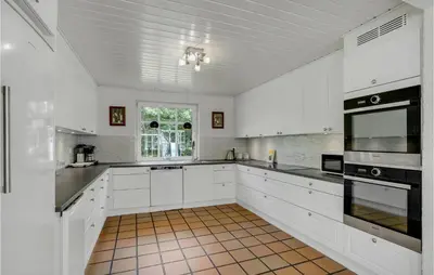a white kitchen with white cabinets and black appliances at Amazing Home In Vestervig With Sauna in Vestervig
