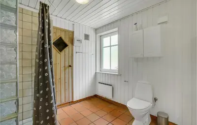 a bathroom with a toilet and a window at Amazing Home In Vestervig With Sauna in Vestervig