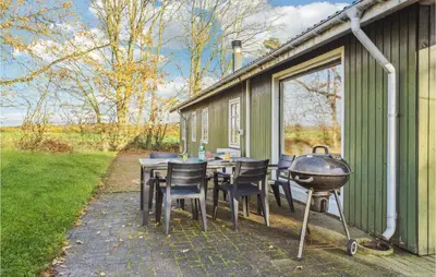 a patio with a grill and a table and chairs at Stunning Home In Nibe With Kitchen in Store Ajstrup