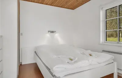 a white bed in a room with a window at Stunning Home In Nibe With Kitchen in Store Ajstrup