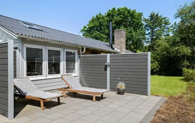 two chairs on a patio in front of a house at Lovely Home In Hurup Thy With Sauna in Sønder Ydby