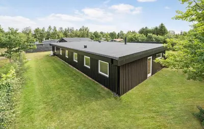 a black house on top of a green field at 5 Bedroom Lovely Home In Højslev in Højslev