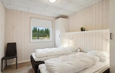 two beds in a room with a window at 5 Bedroom Lovely Home In Højslev in Højslev