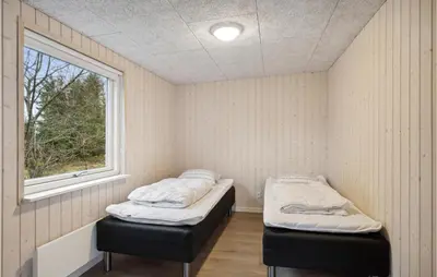 two beds in a room with a window at 5 Bedroom Lovely Home In Højslev in Højslev