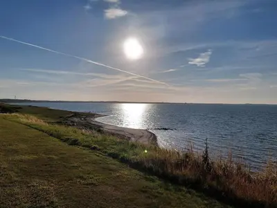 a large body of water with the sun in the sky at Modern Cottage with Spa - By Traum Ferienwohnungen in Vinderup