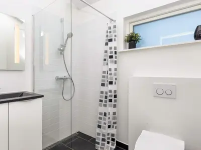a bathroom with a shower with a glass door at Modern Cottage with Spa - By Traum Ferienwohnungen in Vinderup