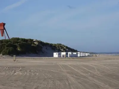a row of white buildings on a beach at 6 person holiday home in Blokhus-By Traum in Blokhus