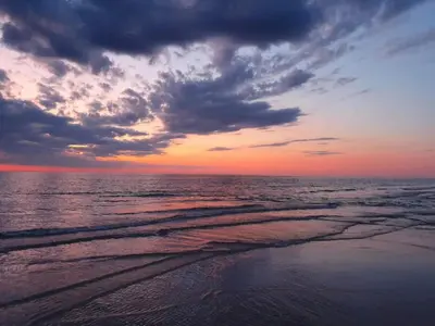 a sunset over the ocean with a cloudy at 6 person holiday home in Blokhus-By Traum in Blokhus