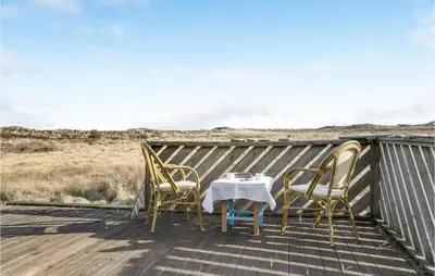 a table and chairs on the deck of a house at 3 Bedroom Lovely Home In Frøstrup in Frøstrup
