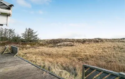 a wooden boardwalk leading to a field of grass at 3 Bedroom Lovely Home In Frøstrup in Frøstrup