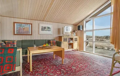 a living room with a couch and a table at 3 Bedroom Lovely Home In Frøstrup in Frøstrup