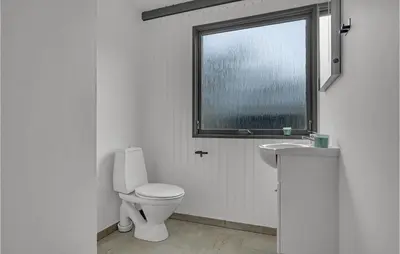 a white bathroom with a toilet and a window at Lovely Home In Hurup Thy With Wifi in Sønder Ydby