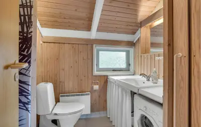 a small bathroom with a toilet and a sink at Gorgeous Home In Blokhus With Wifi in Blokhus