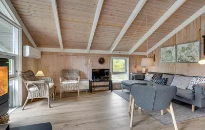 a living room with wooden walls and a wooden ceiling at Gorgeous Home In Blokhus With Wifi in Blokhus