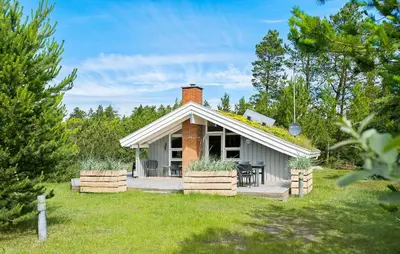 a small white cottage with a porch and a patio at Gorgeous Home In Blokhus With Wifi in Blokhus