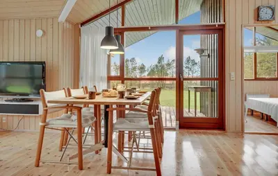 a dining room with a table and chairs and a tv at Amazing Home In Spøttrup With Kitchen in Spottrup