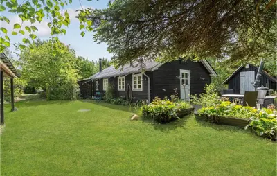 a black house with a yard with a yard at 2 Bedroom Lovely Home In Højslev in Højslev