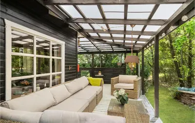 a screened in patio with a couch and chairs at 2 Bedroom Lovely Home In Højslev in Højslev