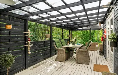 an outdoor deck with a pergola and a table and chairs at 2 Bedroom Lovely Home In Højslev in Højslev