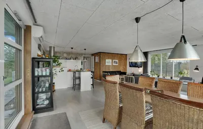 a kitchen with a bar with wicker chairs at 3 Bedroom Cozy Home In Thyholm in Thyholm