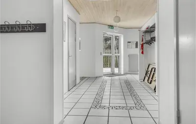 a hallway with white walls and a tile floor at 5 Bedroom Stunning Home In Hanstholm in Hanstholm