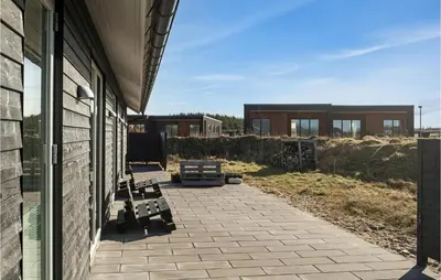 a patio with benches on the side of a building at Beautiful Home In Thisted With Sauna in Thisted